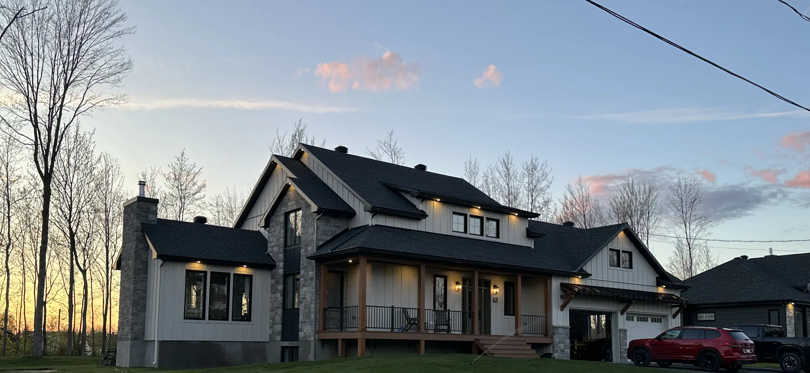 Maison neuve au crépuscule, revêtement de planches et de pierre